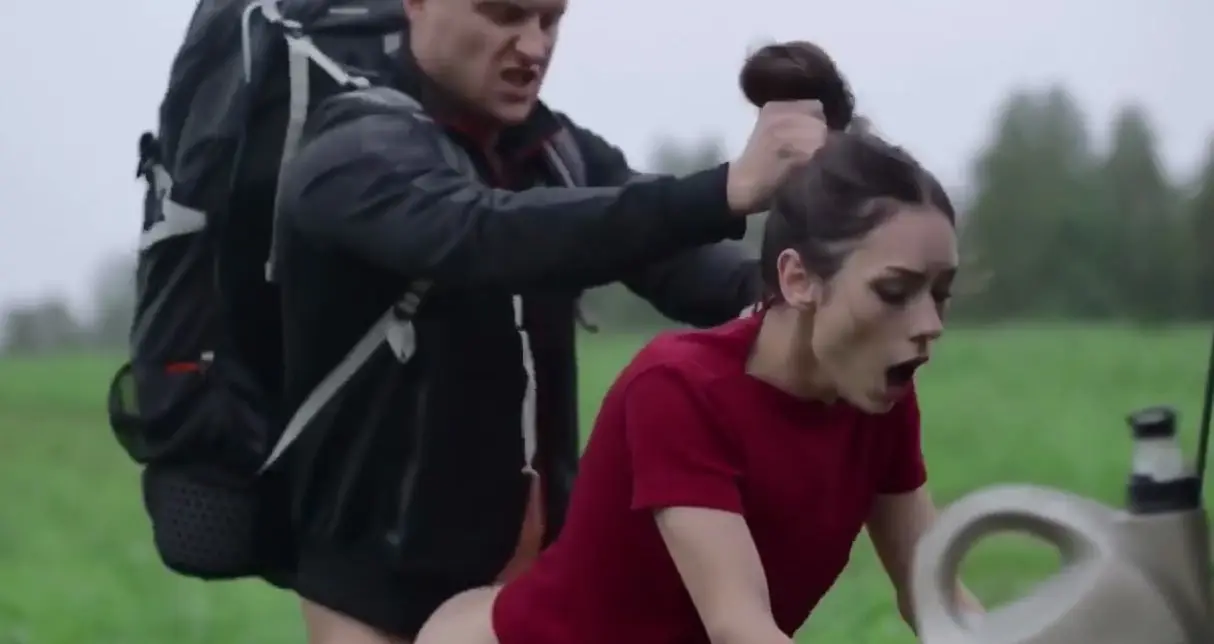 A tourist helps a Russian girl start a car in the forest